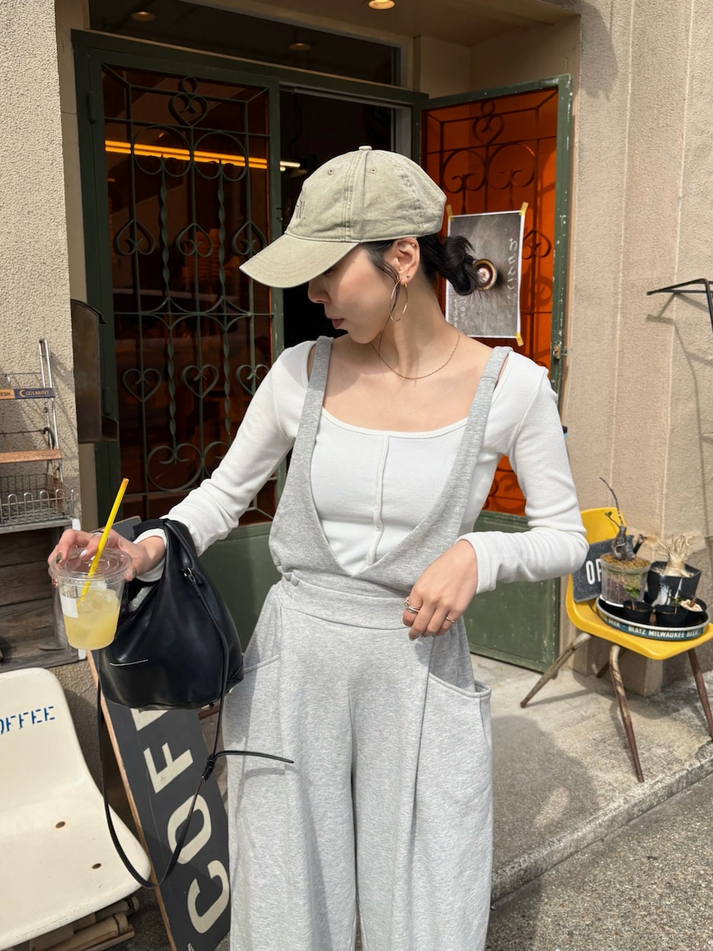 ブラック系のショルダーバッグ、ブラック系のサンダル、シルバー系のネックレスを着用したレディースの春コーディネートの5枚目の写真