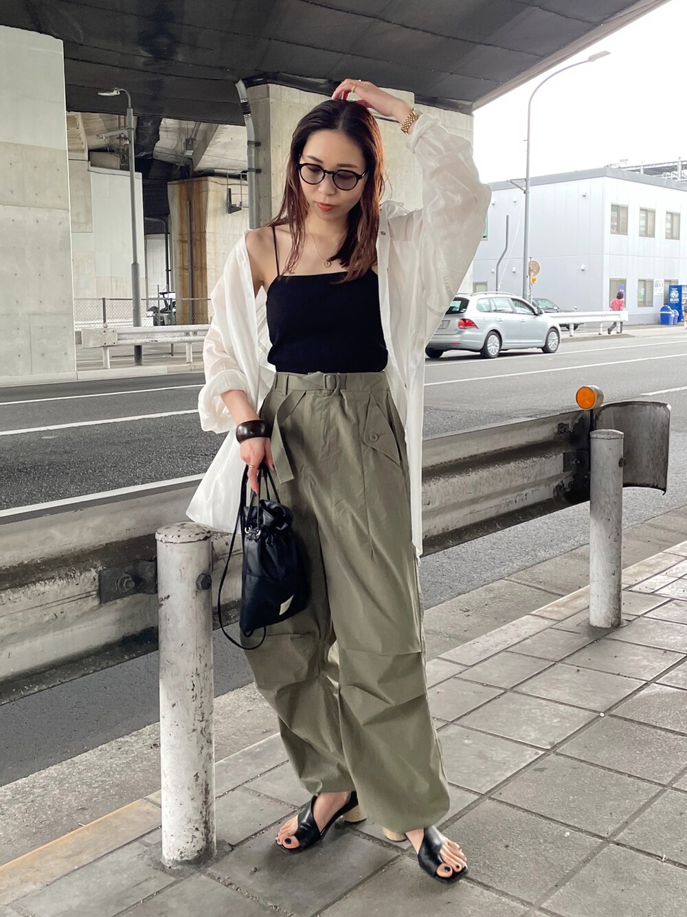 ブラック系のキャミソール、ホワイト系のシャツ/ブラウス、ブラック系のショルダーバッグを着用したレディースの春コーディネートの2枚目の写真