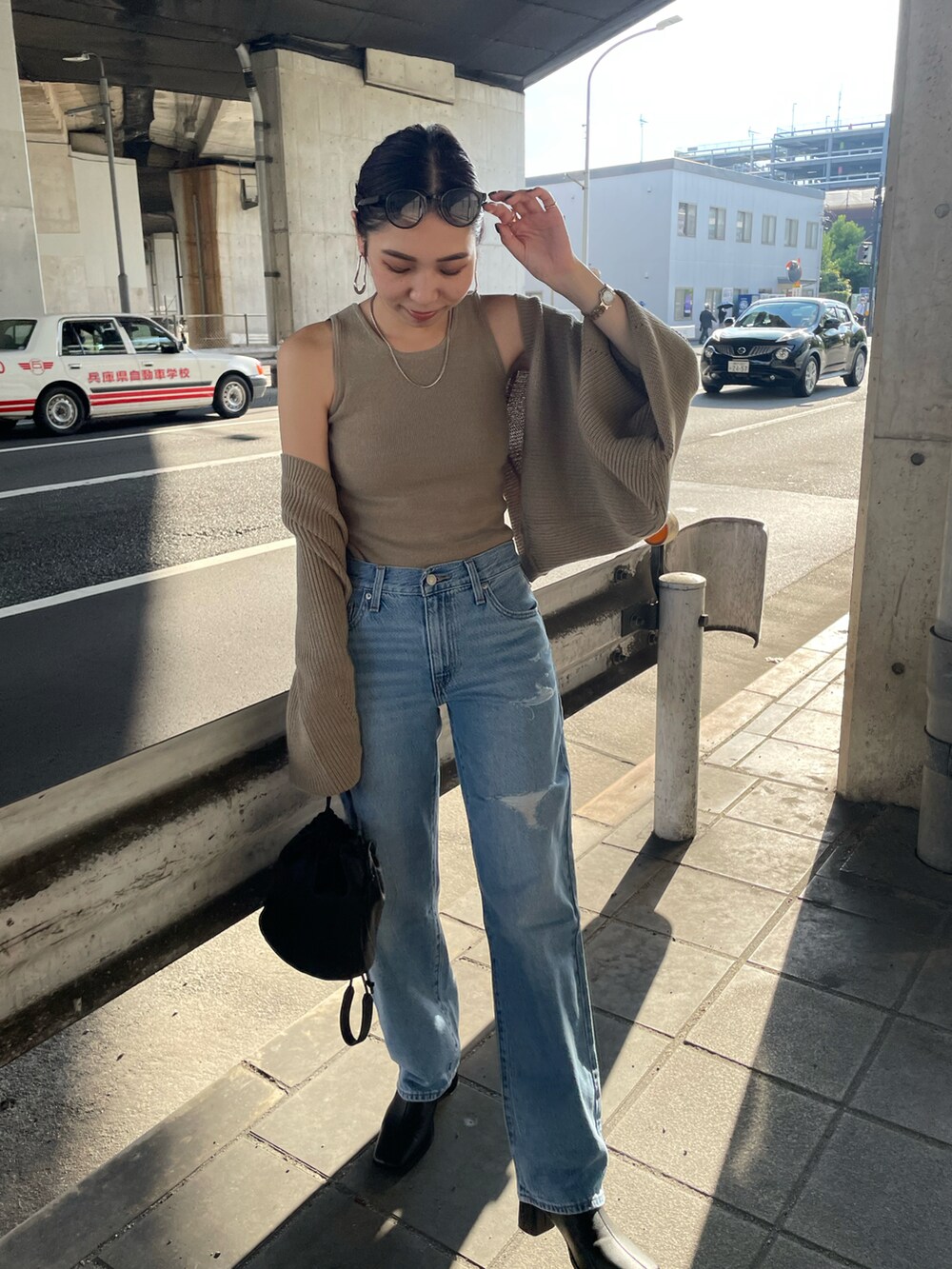 ベージュ系のカーディガン/ボレロ、ブラック系のハンドバッグ、ブラック系のブーツを着用したレディースの秋コーディネートの5枚目の写真