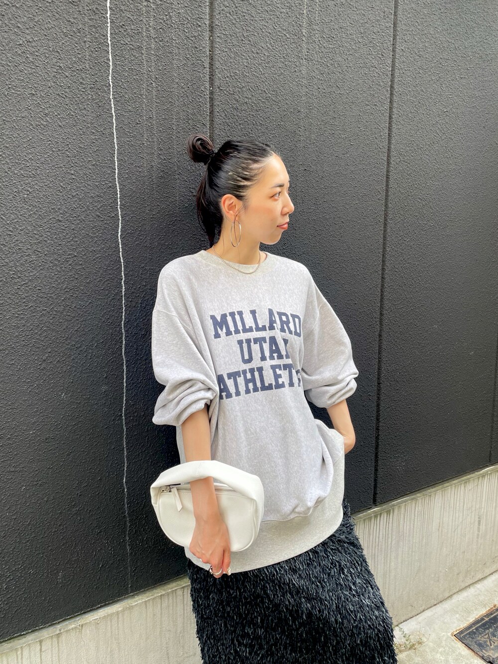 ブラック系のスカート、グレー系のスウェット、ブラック系のスニーカーを着用したレディースの秋コーディネートの5枚目の写真