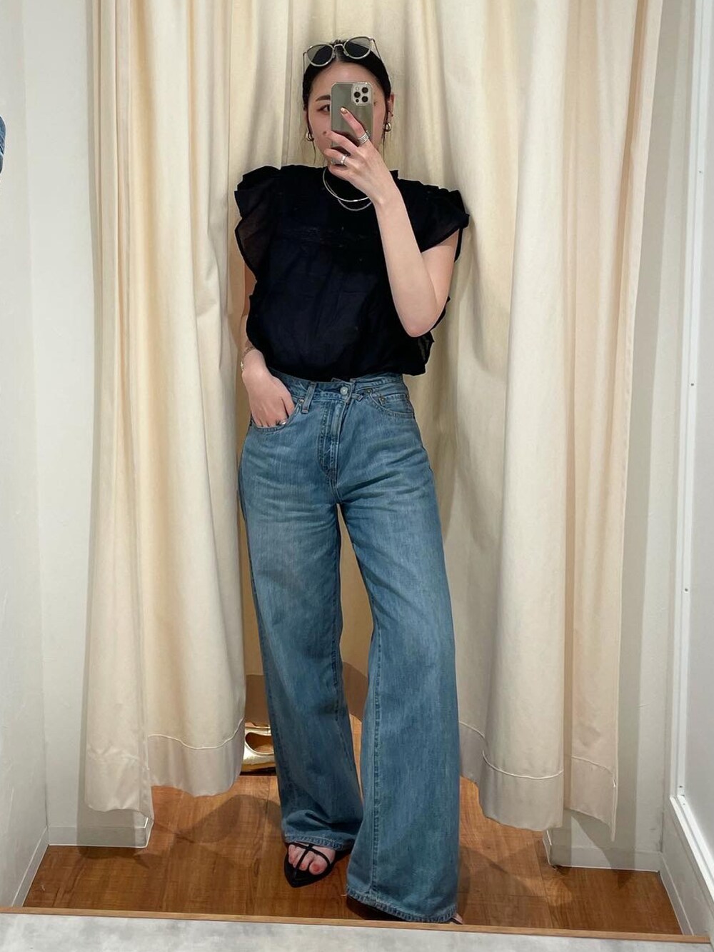 ブラック系のサンダル、ブルー系のデニムパンツ、ブラック系のシャツ/ブラウスを着用したレディースの春コーディネートの2枚目の写真