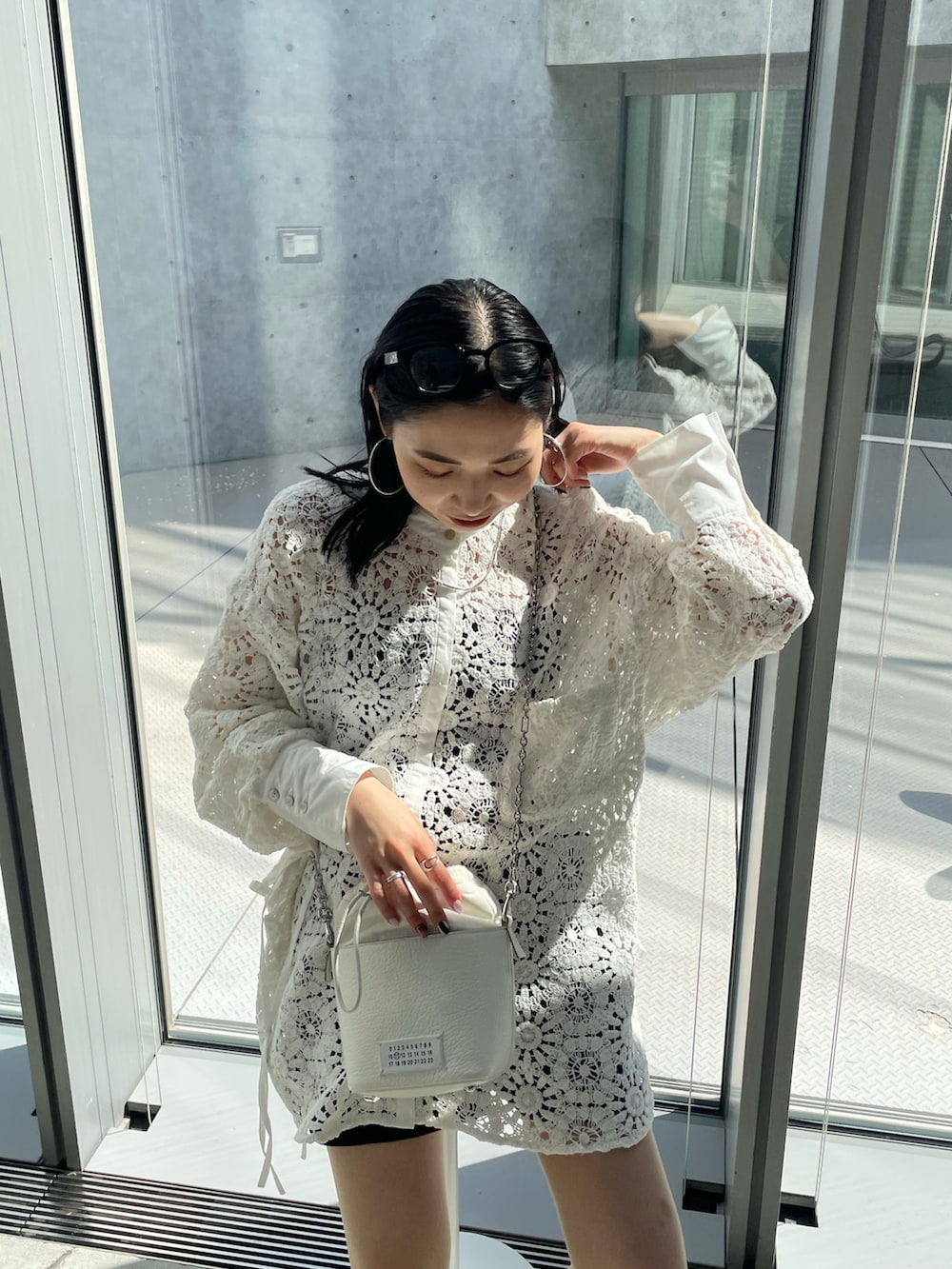 ブラック系のブーツ、ホワイト系のシャツ/ブラウス、ホワイト系のショルダーバッグを着用したレディースの春コーディネートの4枚目の写真