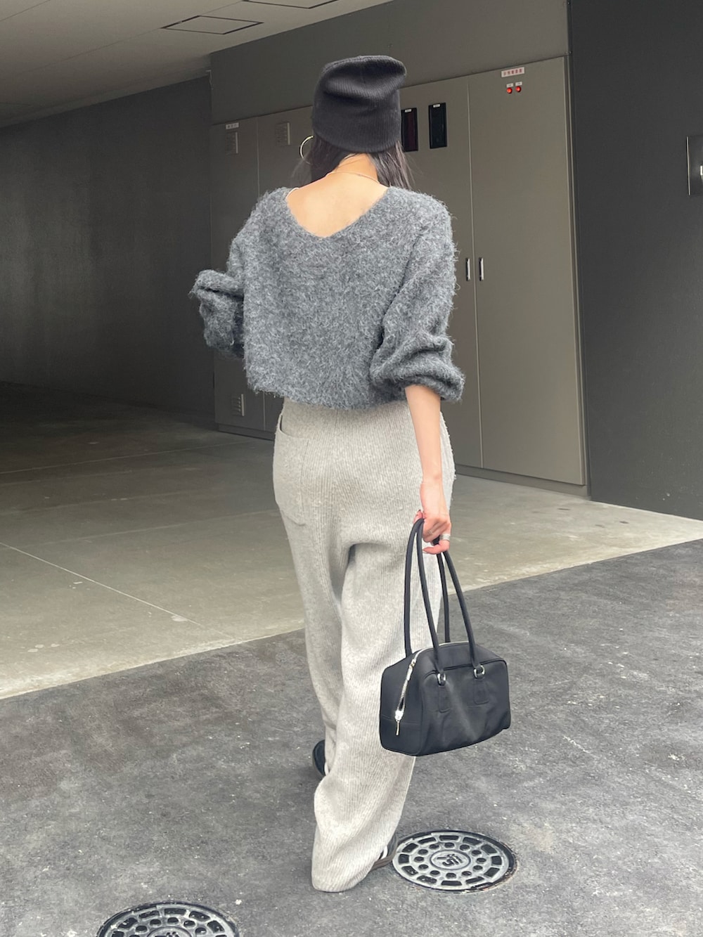 グレー系のニット/セーター、グレー系のその他パンツ、ブラック系のハンドバッグを着用したレディースの秋コーディネートの2枚目の写真