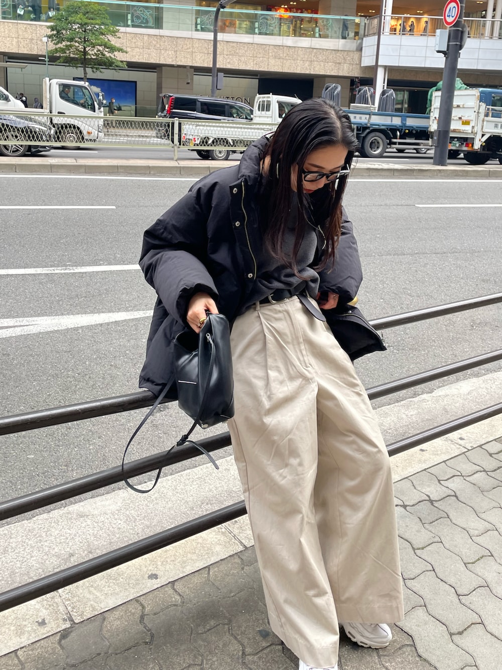 ブラック系のショルダーバッグ、ホワイト系のその他パンツ、ブラック系のダウンジャケット/コートを着用したレディースの冬コーディネートの3枚目の写真