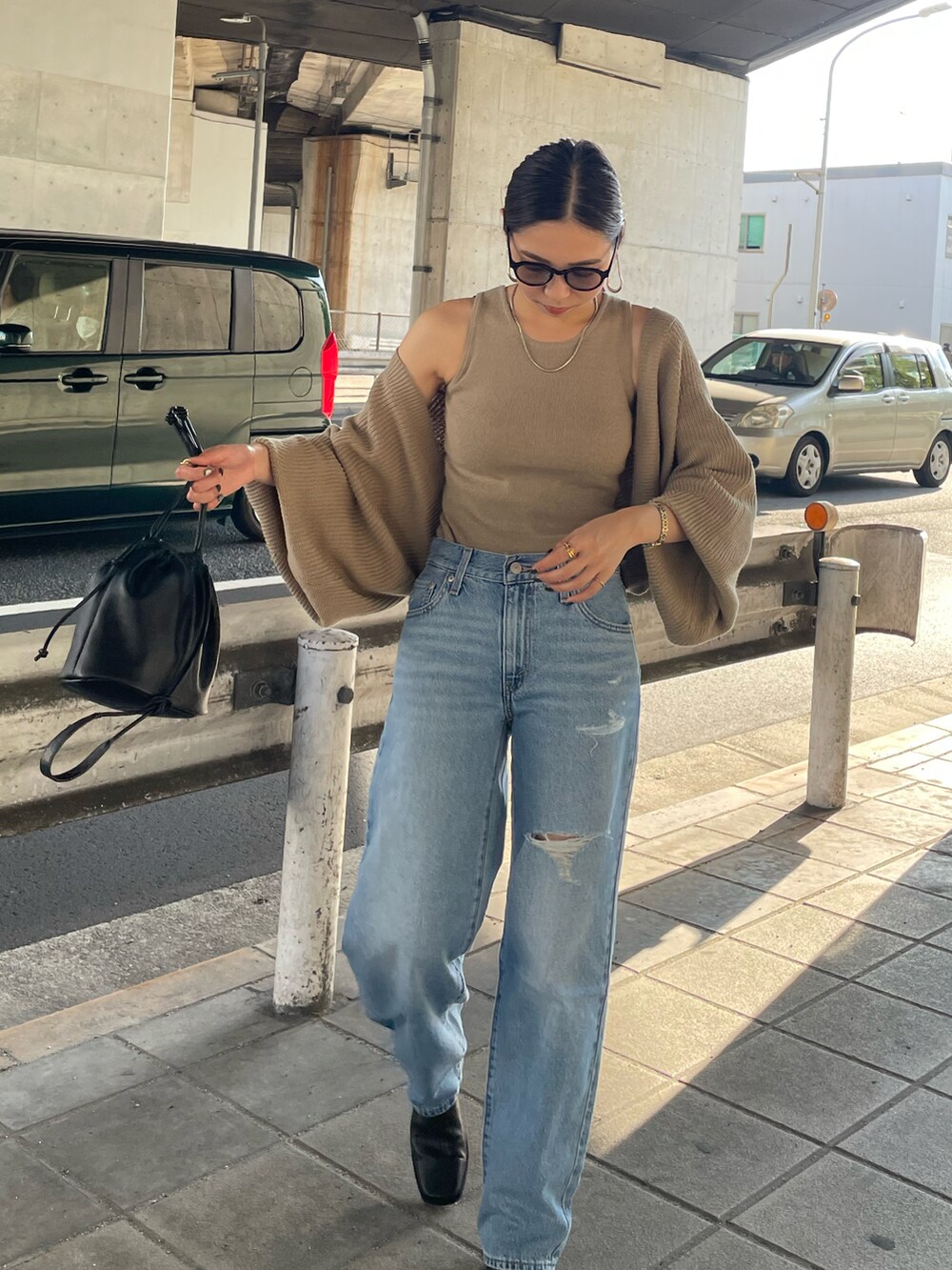 ベージュ系のカーディガン/ボレロ、ブラック系のハンドバッグ、ブラック系のブーツを着用したレディースの秋コーディネートの4枚目の写真