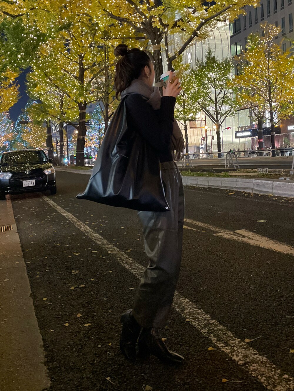 ブラック系のブーツ、ブラック系のニット/セーター、ブラック系のハンドバッグを着用したレディースの秋コーディネートの5枚目の写真