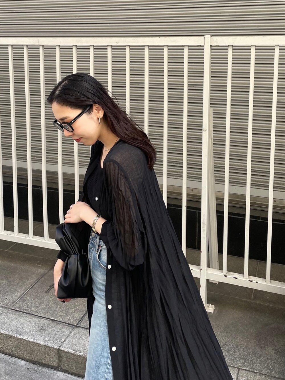 ブラック系のパンプス、ブルー系のデニムパンツ、ブラック系のタンクトップを着用したレディースの春コーディネートの3枚目の写真