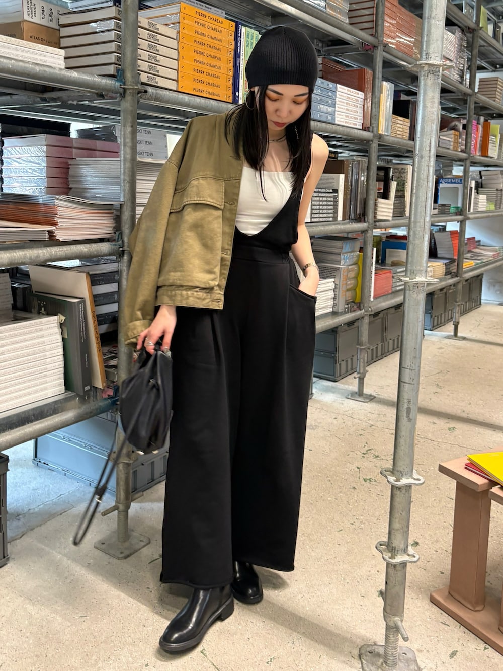 ブラック系のショルダーバッグ、ブラック系のブーツ、ブラック系のニットキャップ/ビーニーを着用したレディースの春コーディネートの2枚目の写真