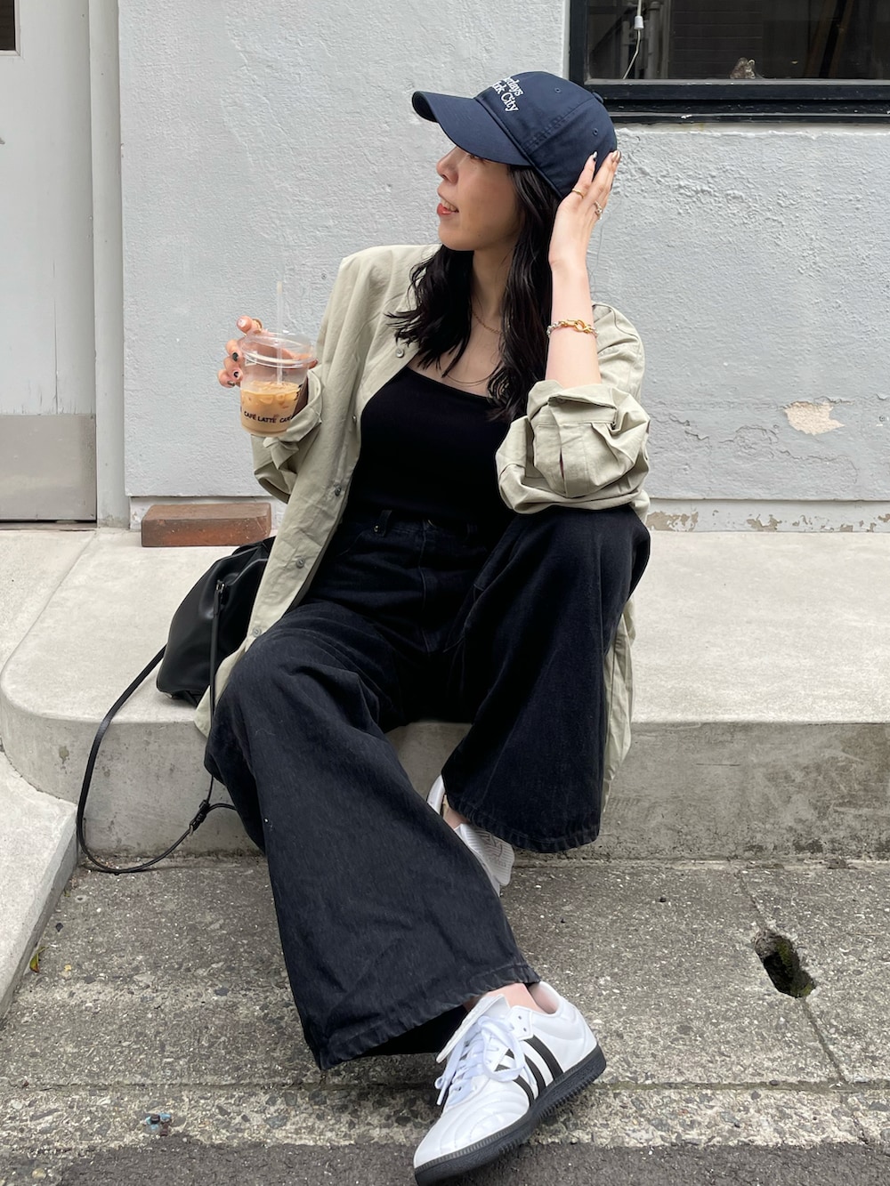 ホワイト系のスニーカー、ブラック系のショルダーバッグ、ブラック系のキャミソールを着用したレディースの春コーディネートの2枚目の写真