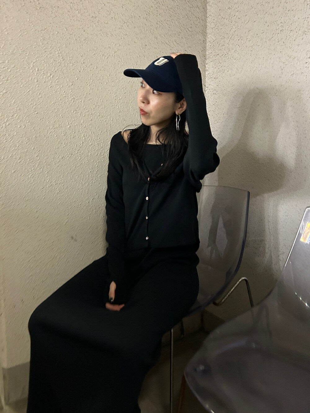 ブラック系のワンピース、ブラック系のブーツ、ブルー系のキャップを着用したレディースの春コーディネートの4枚目の写真