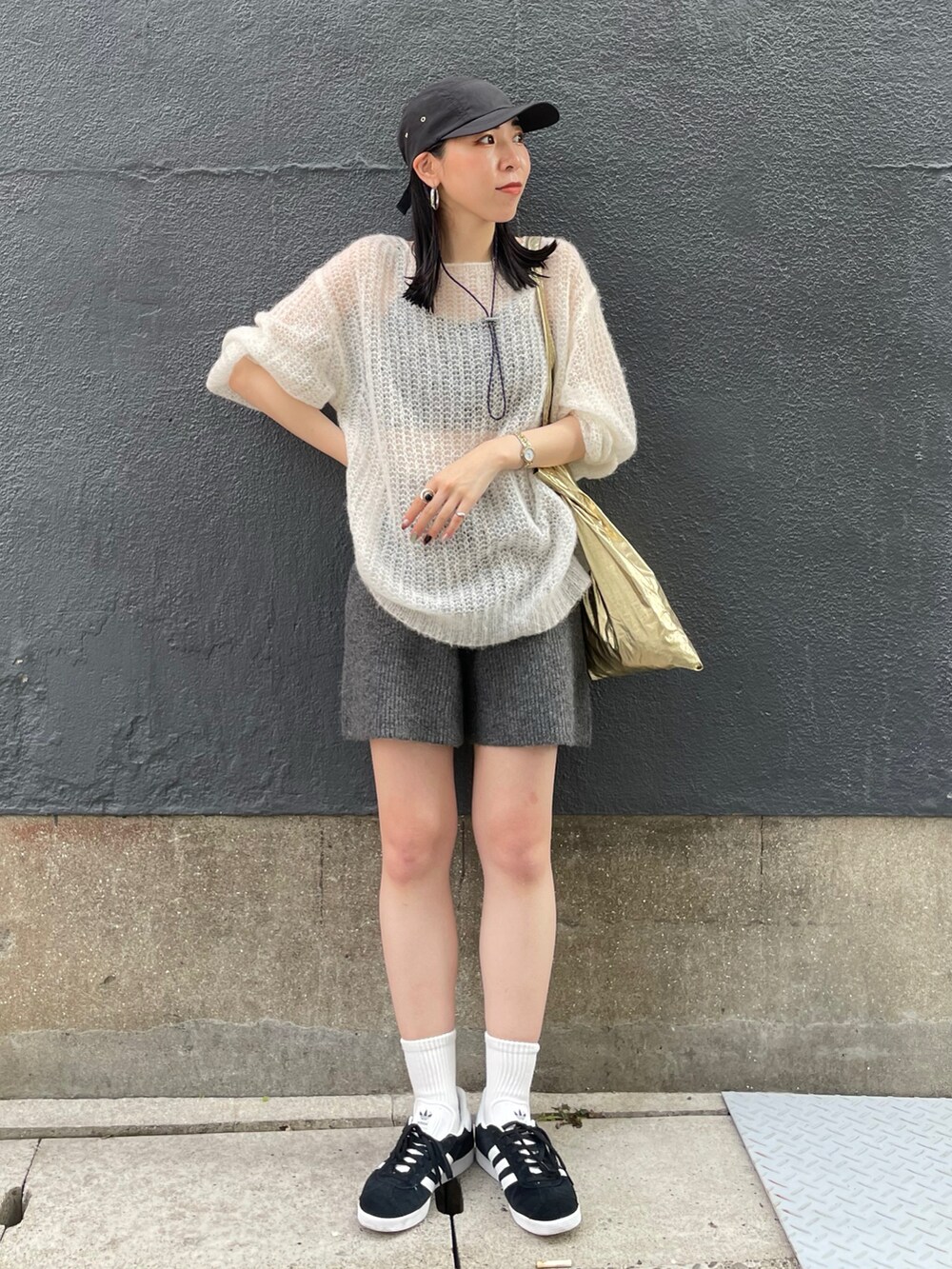 ブラック系のスニーカー、ホワイト系のニット/セーター、グレー系のその他パンツを着用したレディースの秋コーディネートの5枚目の写真