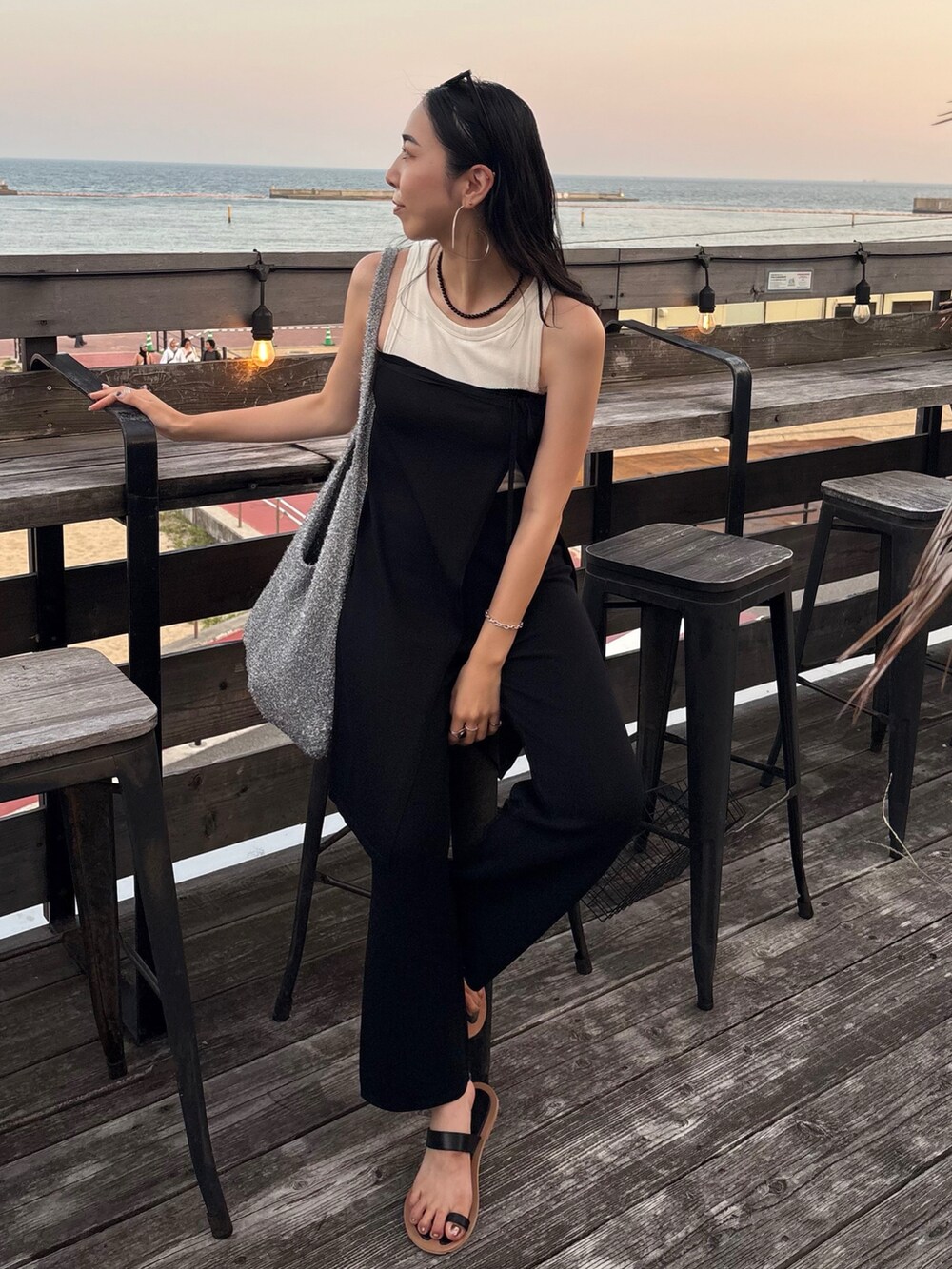 ブラック系のサンダル、シルバー系のトートバッグを着用したレディースの夏コーディネートの2枚目の写真