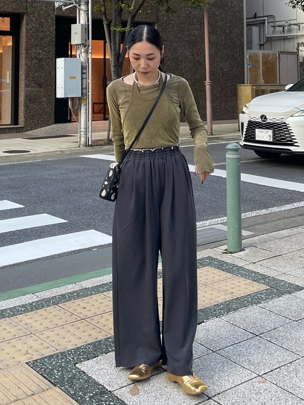 グレー系のその他パンツ、グリーン系のTシャツ/カットソー、ゴールド系のパンプスを着用したレディースの秋コーディネートの5枚目の写真