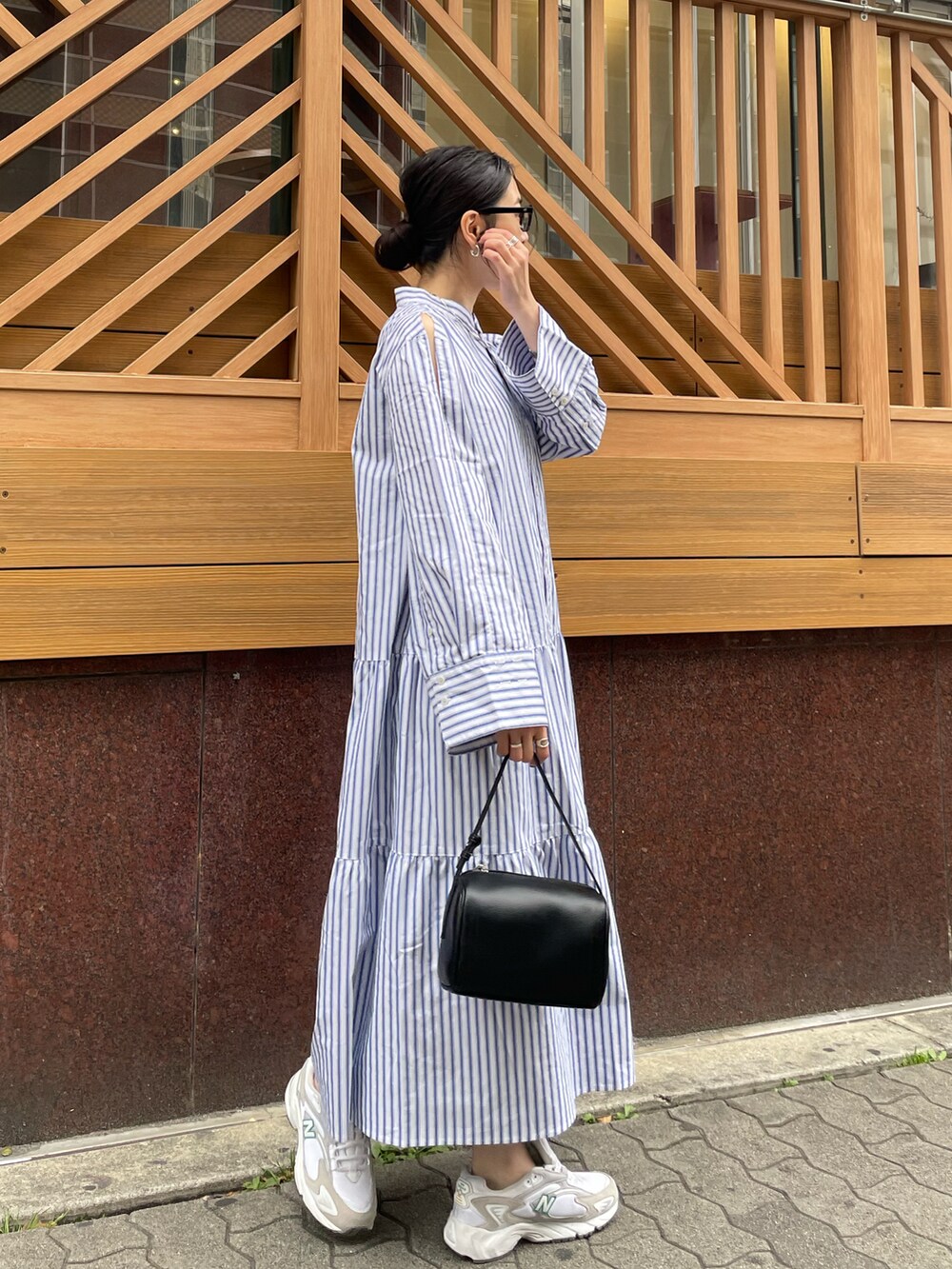 ブラック系のハンドバッグ、ホワイト系のスニーカー、その他のワンピースを着用したレディースの春コーディネートの4枚目の写真