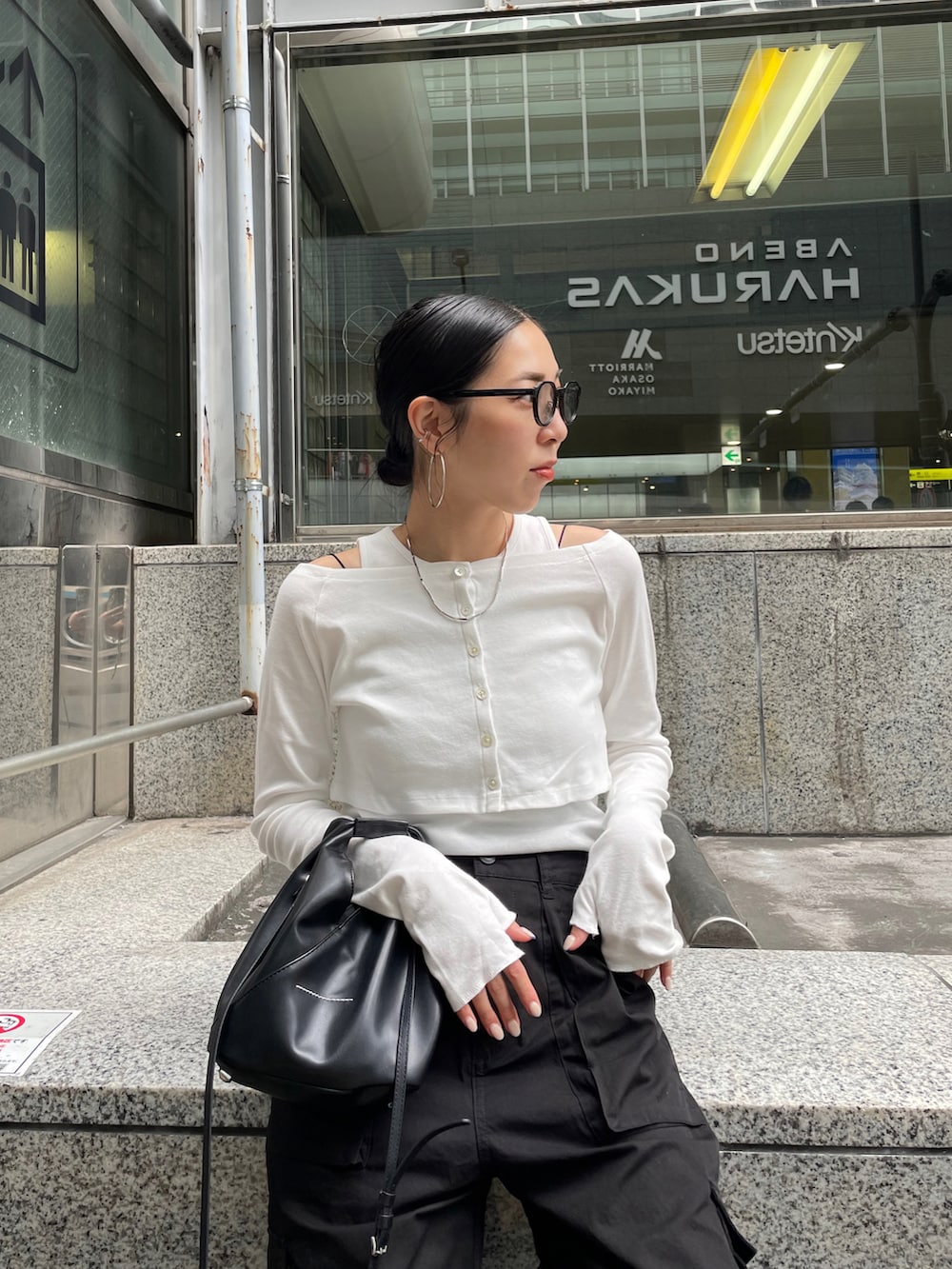 ブラック系のショルダーバッグ、ブラック系のサンダル、ホワイト系のTシャツ/カットソーを着用したレディースの夏コーディネートの4枚目の写真