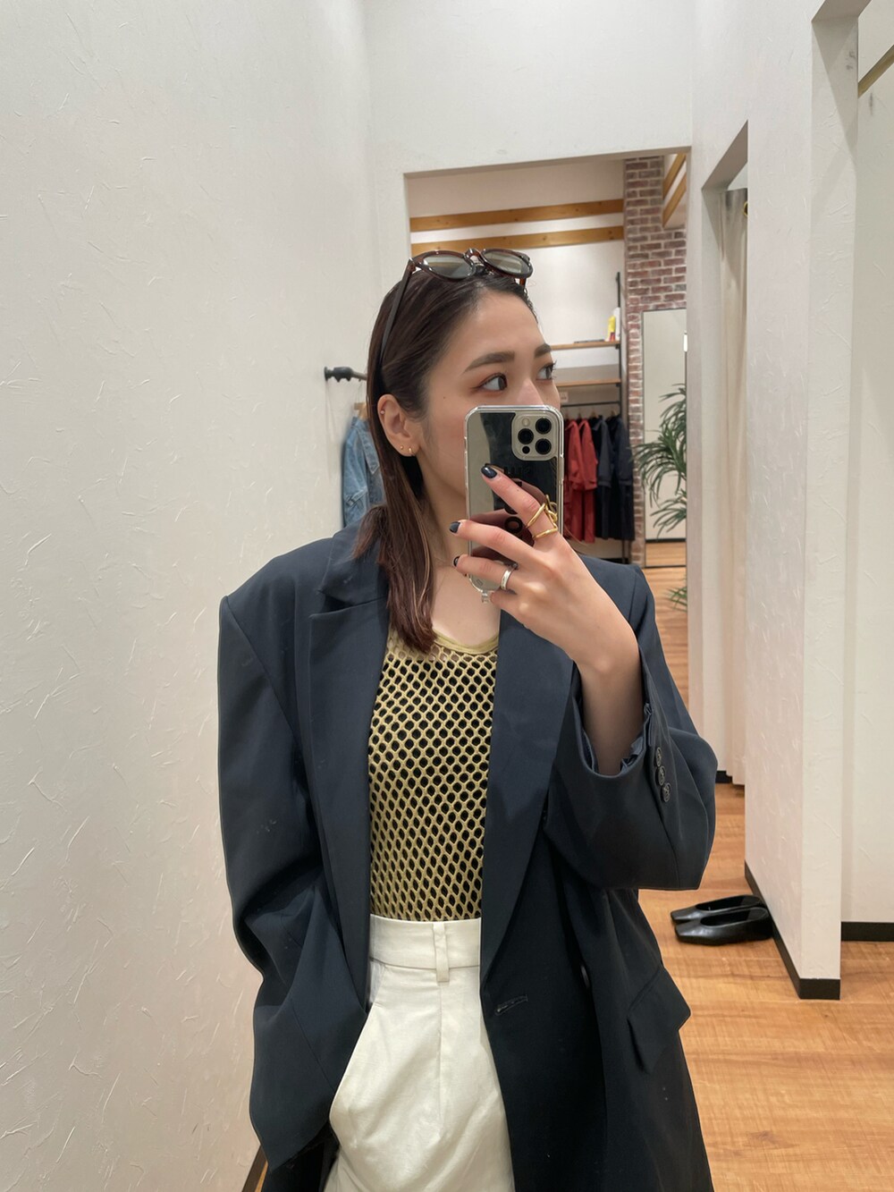 ホワイト系のパンツ、グレー系のテーラードジャケット、グリーン系のタンクトップを着用したレディースの夏コーディネートの5枚目の写真