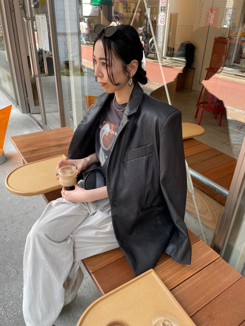 ゴールド系のパンプス、ブラック系のテーラードジャケット、ブラック系のショルダーバッグを着用したレディースの春コーディネートの3枚目の写真