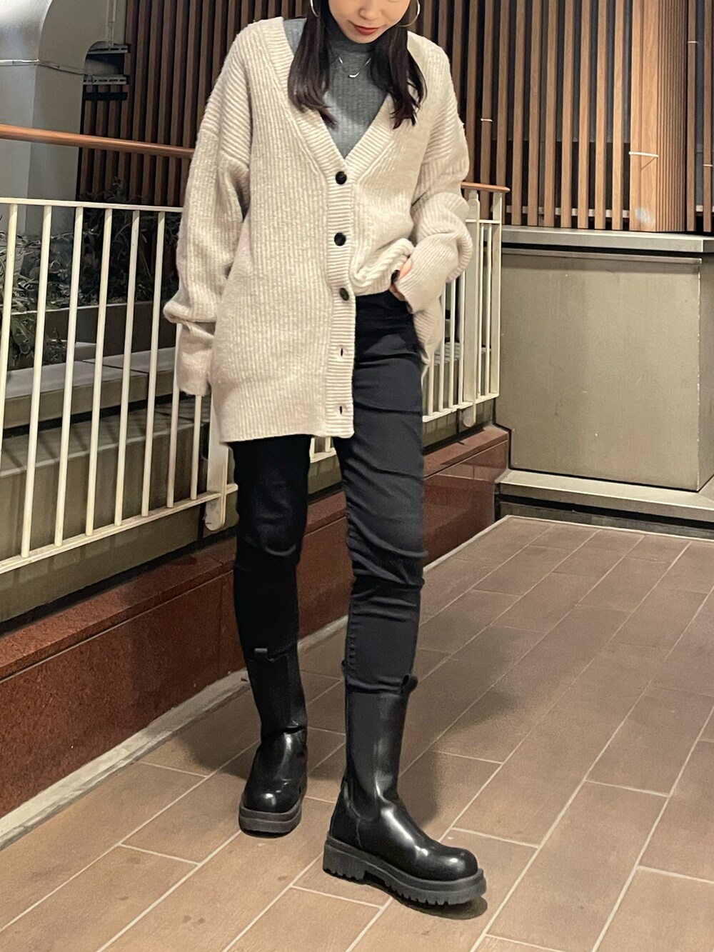 ホワイト系のカーディガン/ボレロ、ブラック系のデニムパンツ、ブラック系のブーツを着用したレディースの冬コーディネートの2枚目の写真