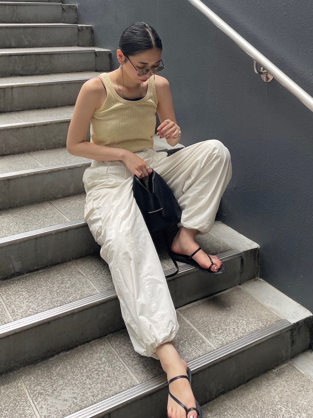 ホワイト系のカーゴパンツ、イエロー系のTシャツ/カットソー、ブラック系のショルダーバッグを着用したレディースの夏コーディネートの3枚目の写真