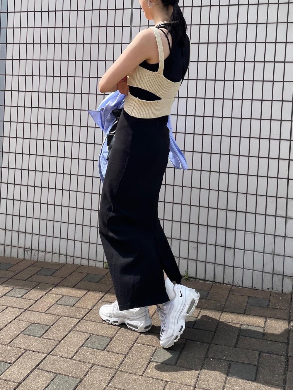 ブラック系のワンピース、ホワイト系のニット/セーター、ホワイト系のスニーカーを着用したレディースの夏コーディネートの4枚目の写真