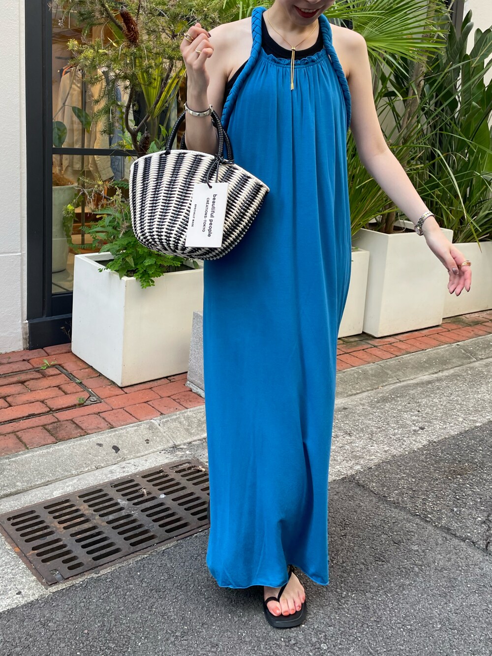 ブルー系のワンピース、ブラック系のハンドバッグを着用したレディースの夏コーディネートの3枚目の写真
