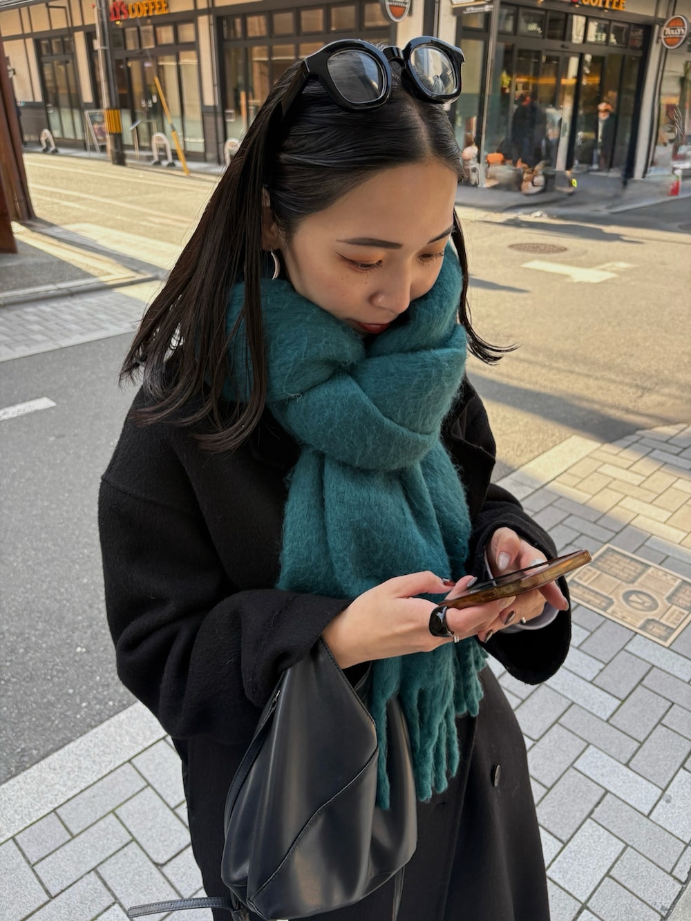 ブラック系のブーツ、ブラック系のショルダーバッグを着用したレディースの秋コーディネートの5枚目の写真