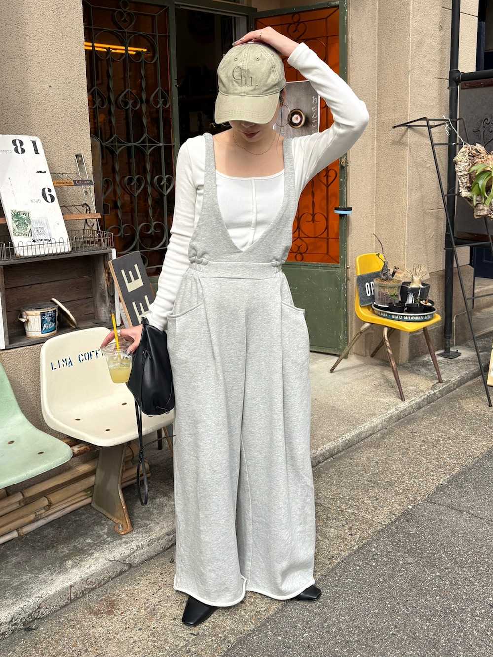 ブラック系のショルダーバッグ、ブラック系のサンダル、シルバー系のネックレスを着用したレディースの春コーディネートの3枚目の写真