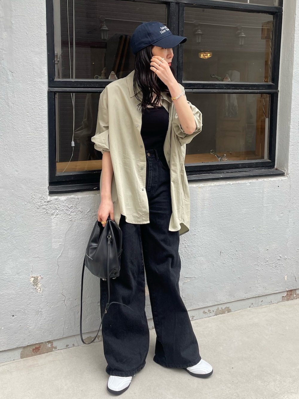 ホワイト系のスニーカー、ブラック系のショルダーバッグ、ブラック系のキャミソールを着用したレディースの春コーディネートの5枚目の写真