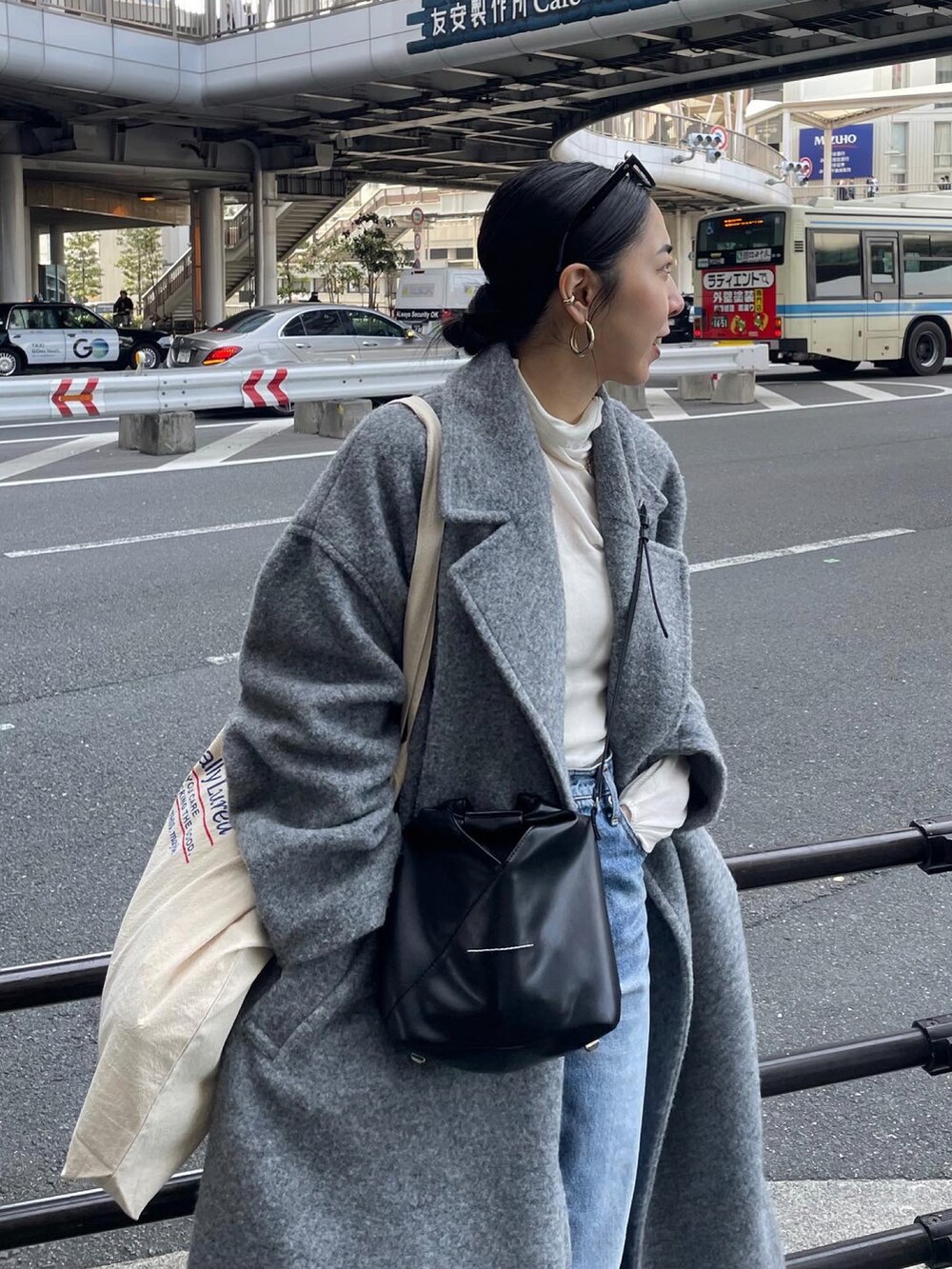 ブラック系のブーツ、ブルー系のデニムパンツ、ブラック系のショルダーバッグを着用したレディースの冬コーディネートの5枚目の写真