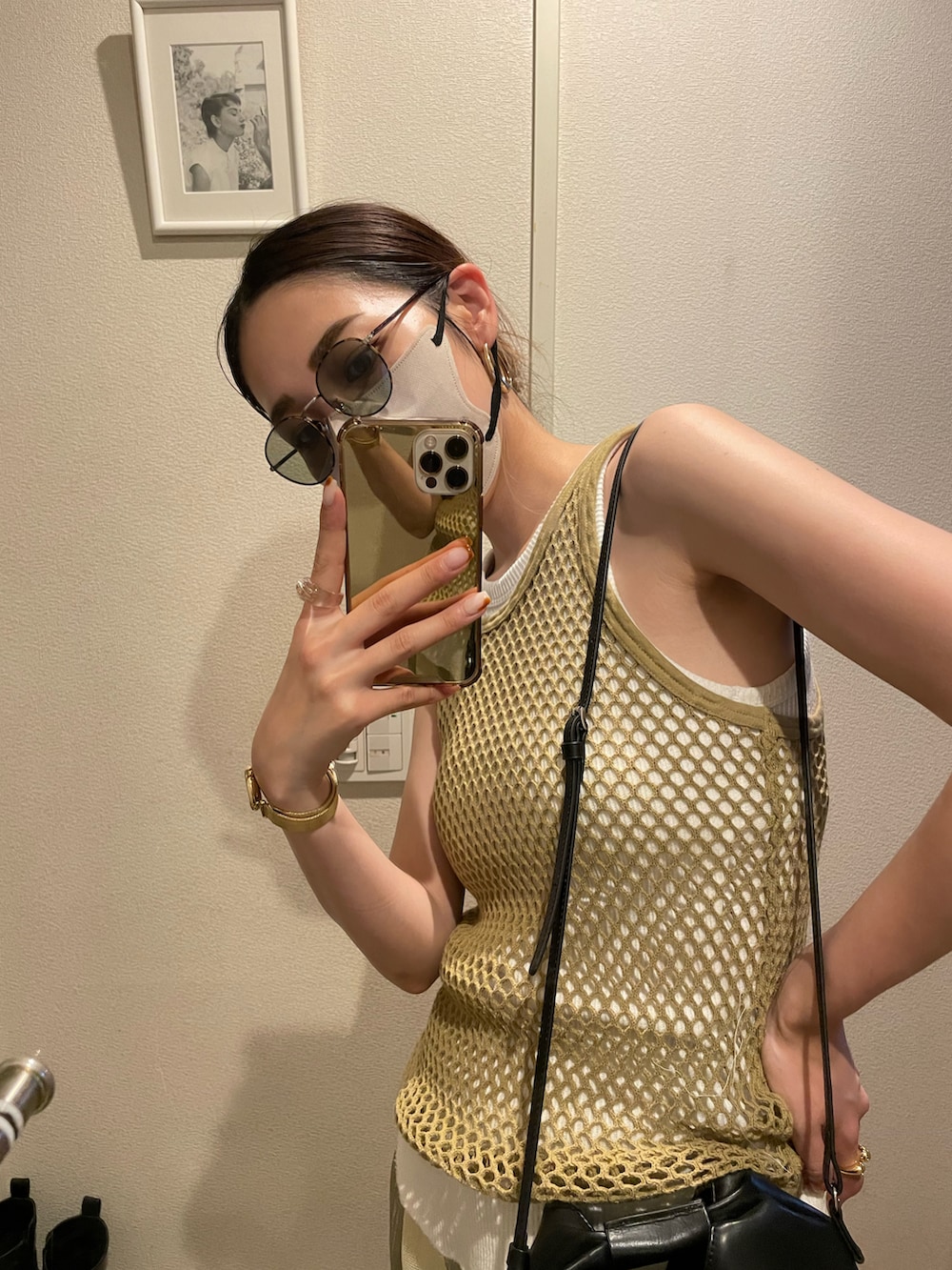 グリーン系のタンクトップ、ブラック系のショルダーバッグ、ベージュ系のその他パンツを着用したレディースの夏コーディネートの3枚目の写真