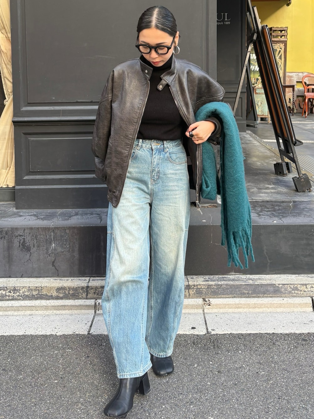 ブラック系のブーツ、ブラック系のショルダーバッグを着用したレディースの秋コーディネートの2枚目の写真