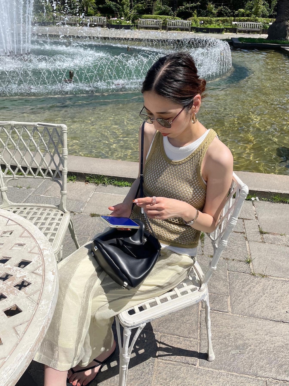 グリーン系のタンクトップ、ブラック系のショルダーバッグ、ベージュ系のその他パンツを着用したレディースの夏コーディネートの4枚目の写真