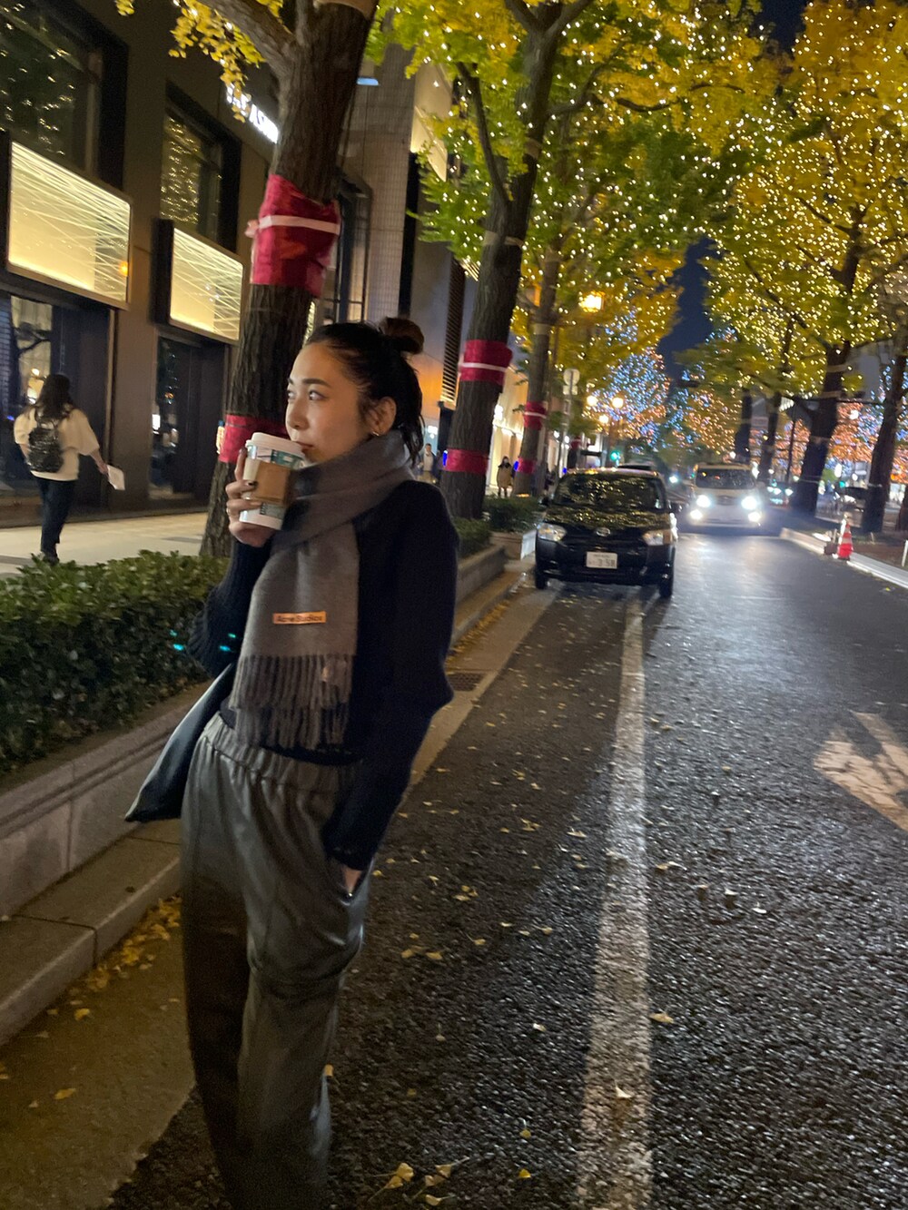 ブラック系のブーツ、ブラック系のニット/セーター、ブラック系のハンドバッグを着用したレディースの秋コーディネートの4枚目の写真