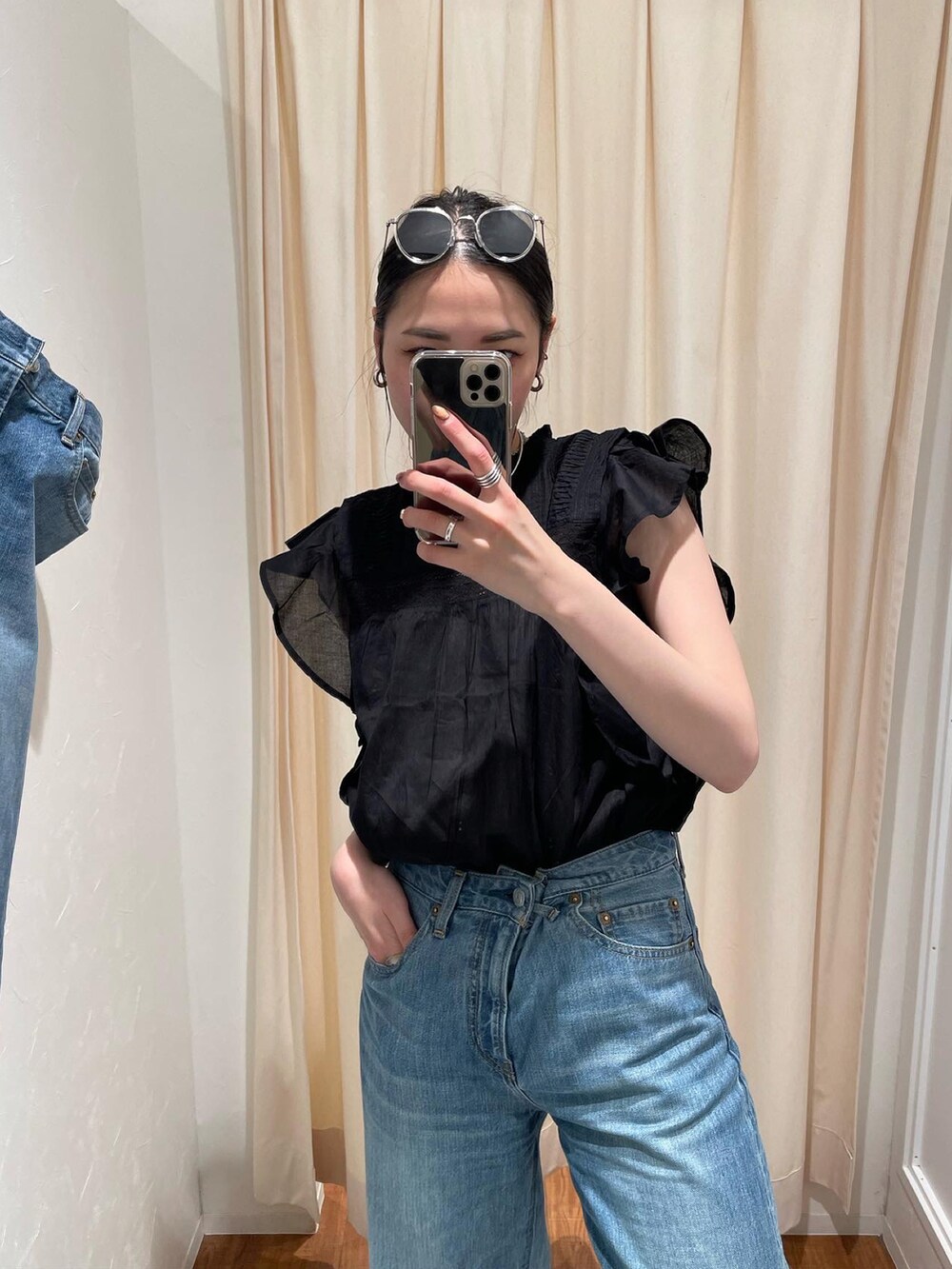 ブラック系のサンダル、ブルー系のデニムパンツ、ブラック系のシャツ/ブラウスを着用したレディースの春コーディネートの3枚目の写真