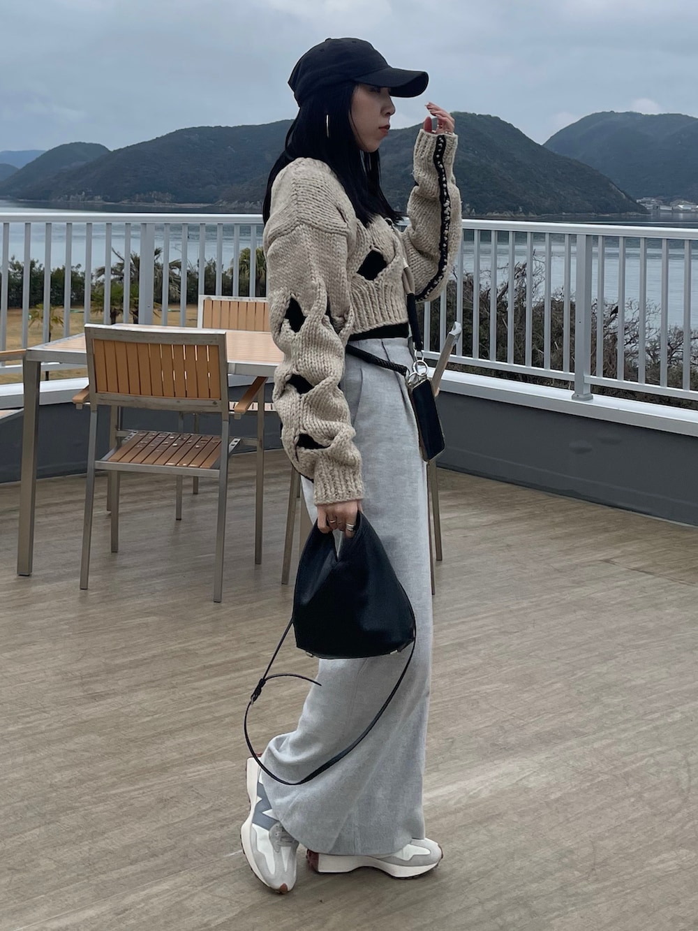 ホワイト系のニット/セーター、グレー系のその他パンツ、ブラック系のショルダーバッグを着用したレディースの冬コーディネートの2枚目の写真