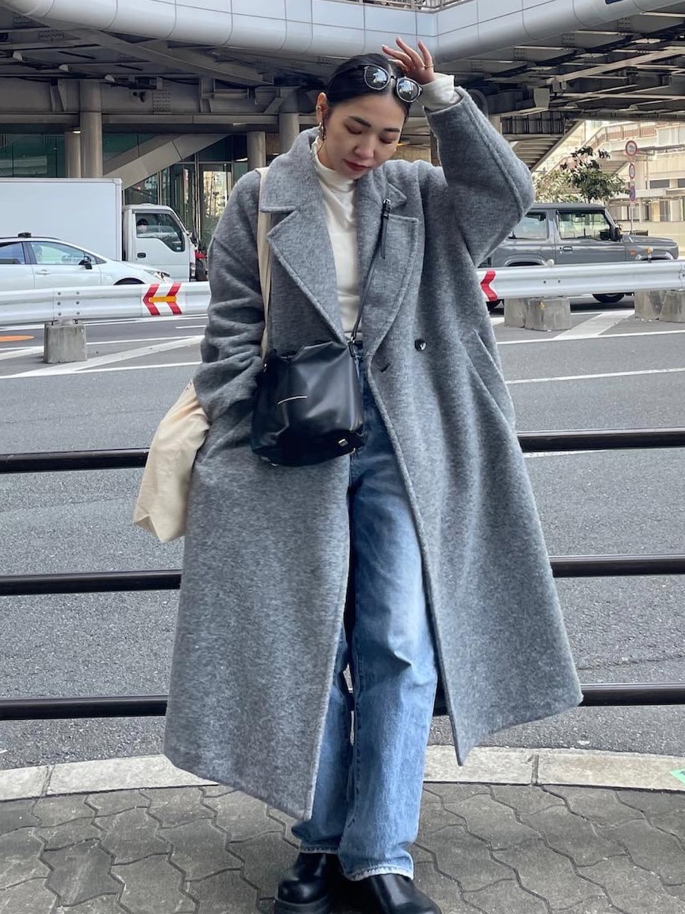 ブラック系のブーツ、ブルー系のデニムパンツ、ブラック系のショルダーバッグを着用したレディースの冬コーディネートの3枚目の写真