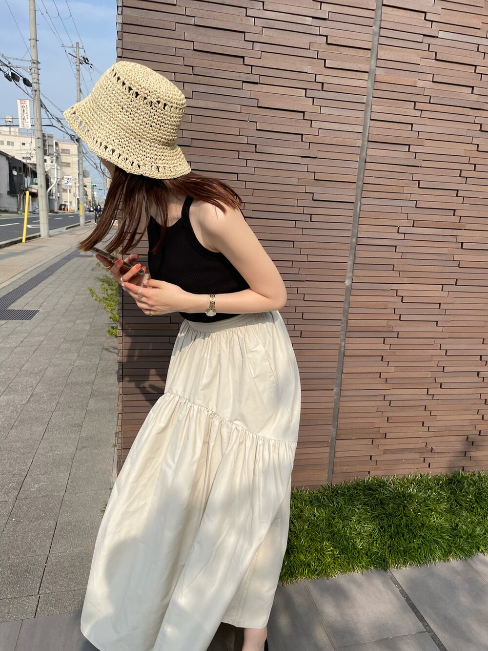 ブラック系のタンクトップ、ホワイト系のスカート、ブラック系のサンダルを着用したレディースの夏コーディネートの5枚目の写真