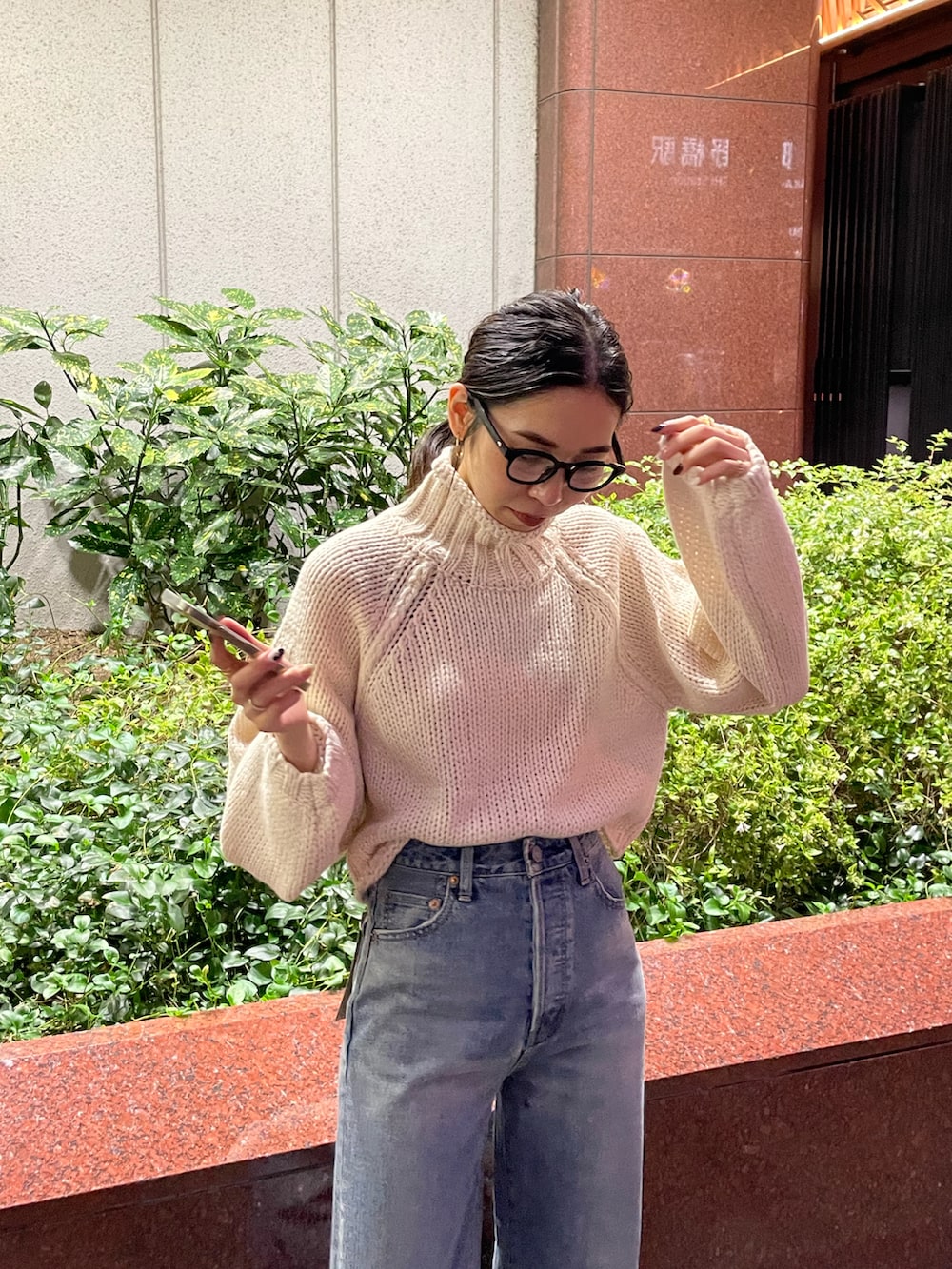 グリーン系のブルゾン、ブルー系のデニムパンツ、ホワイト系のニット/セーターを着用したレディースの秋コーディネートの5枚目の写真