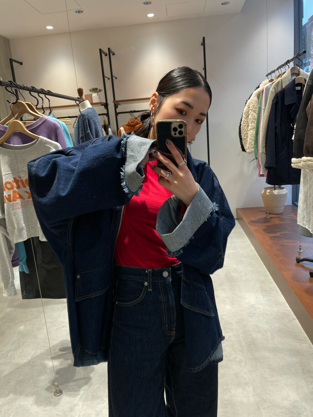 ブルー系のデニムパンツ、ベージュ系のスニーカー、ブルー系のデニムジャケットを着用したレディースの秋コーディネートの4枚目の写真