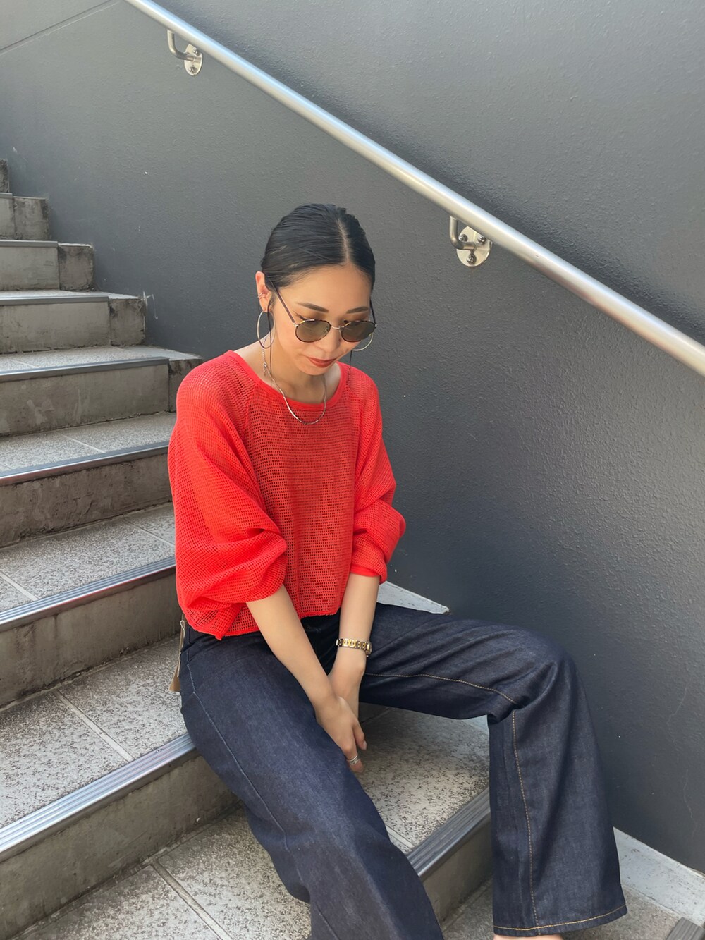 ブラック系のサンダル、ブルー系のデニムパンツ、レッド系のTシャツ/カットソーを着用したレディースの夏コーディネートの4枚目の写真