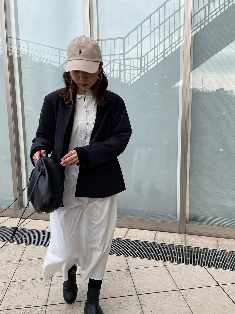 ブラック系のテーラードジャケット、ブラック系のショルダーバッグ、ブラック系のブーツを着用したレディースの春コーディネートの3枚目の写真