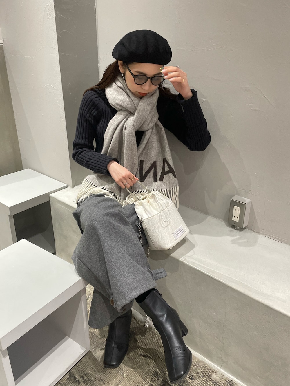 ホワイト系のショルダーバッグ、グレー系のカーゴパンツ、ブラック系のブーツを着用したレディースの冬コーディネートの2枚目の写真