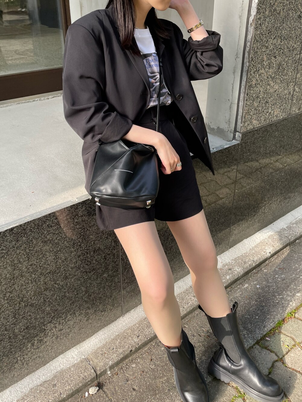 ブラック系のブーツ、ブラック系のショルダーバッグ、ホワイト系のTシャツ/カットソーを着用したレディースの春コーディネートの5枚目の写真