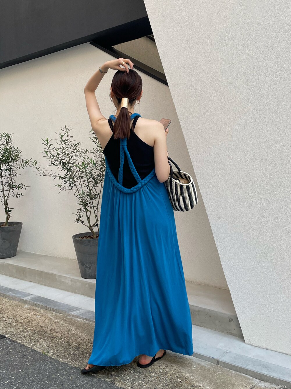 ブルー系のワンピース、ブラック系のハンドバッグを着用したレディースの夏コーディネートの4枚目の写真