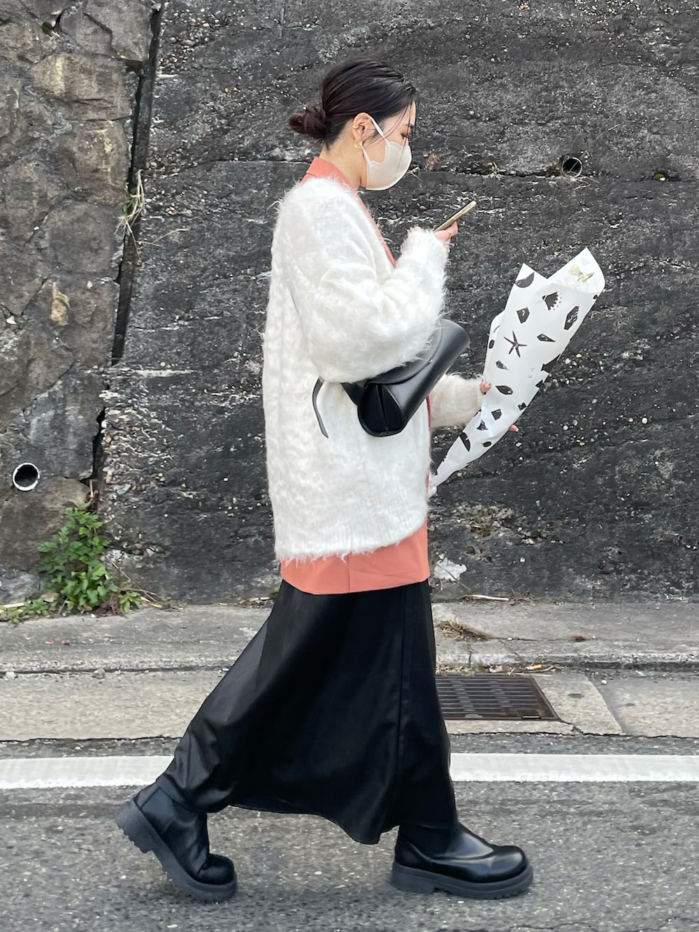 ブラック系のショルダーバッグ、ブラック系のスカート、ホワイト系のカーディガン/ボレロを着用したレディースの冬コーディネートの2枚目の写真