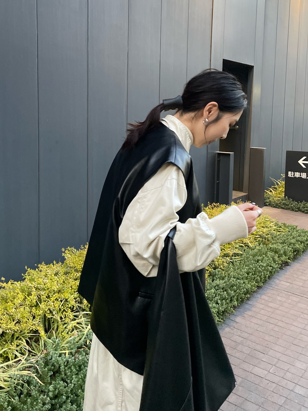 ブラック系のジャケット/アウター、ホワイト系のその他アウター、ブラック系のハンドバッグを着用したレディースの春コーディネートの5枚目の写真