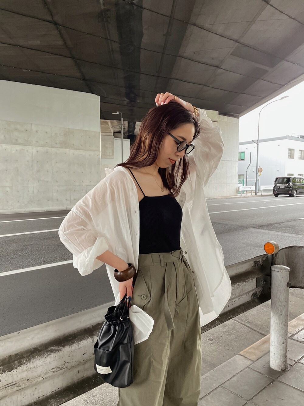 ブラック系のキャミソール、ホワイト系のシャツ/ブラウス、ブラック系のショルダーバッグを着用したレディースの春コーディネートの5枚目の写真