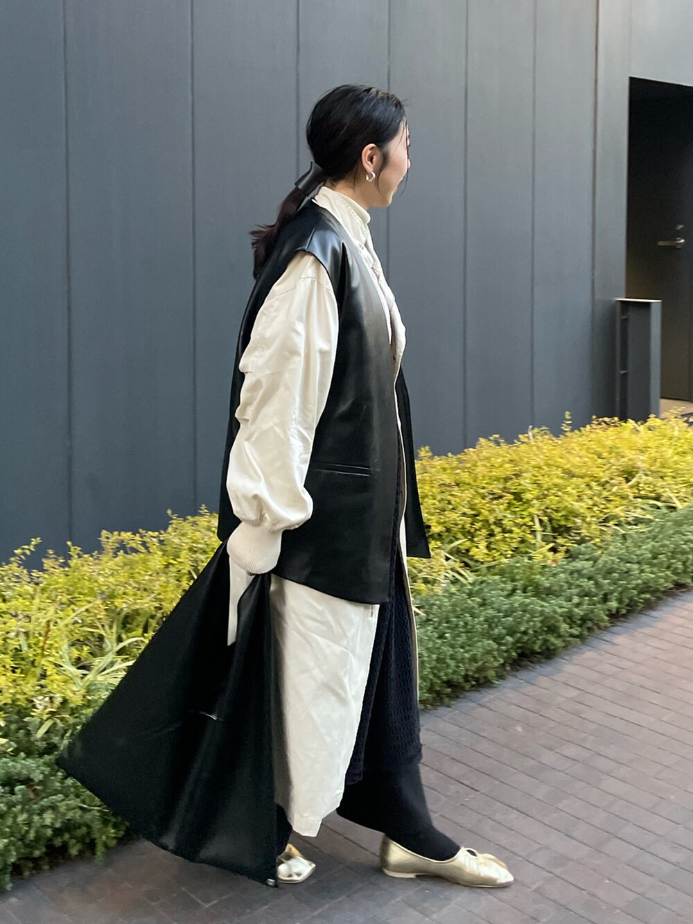 ブラック系のジャケット/アウター、ホワイト系のその他アウター、ブラック系のハンドバッグを着用したレディースの春コーディネートの3枚目の写真