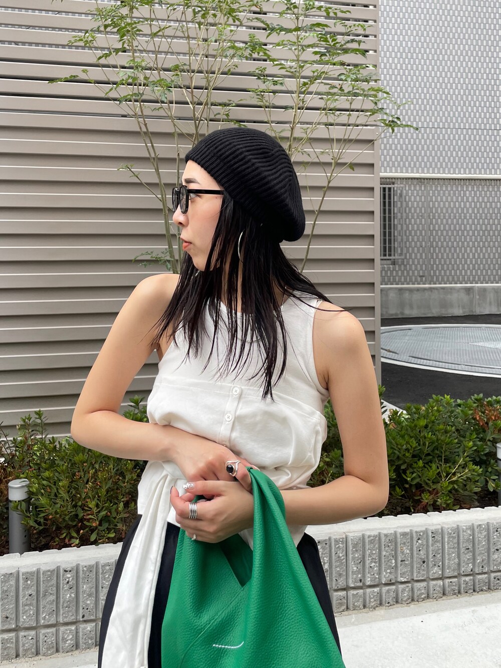 ゴールド系のパンプス、グリーン系のショルダーバッグ、ホワイト系のTシャツ/カットソーを着用したレディースの秋コーディネートの3枚目の写真