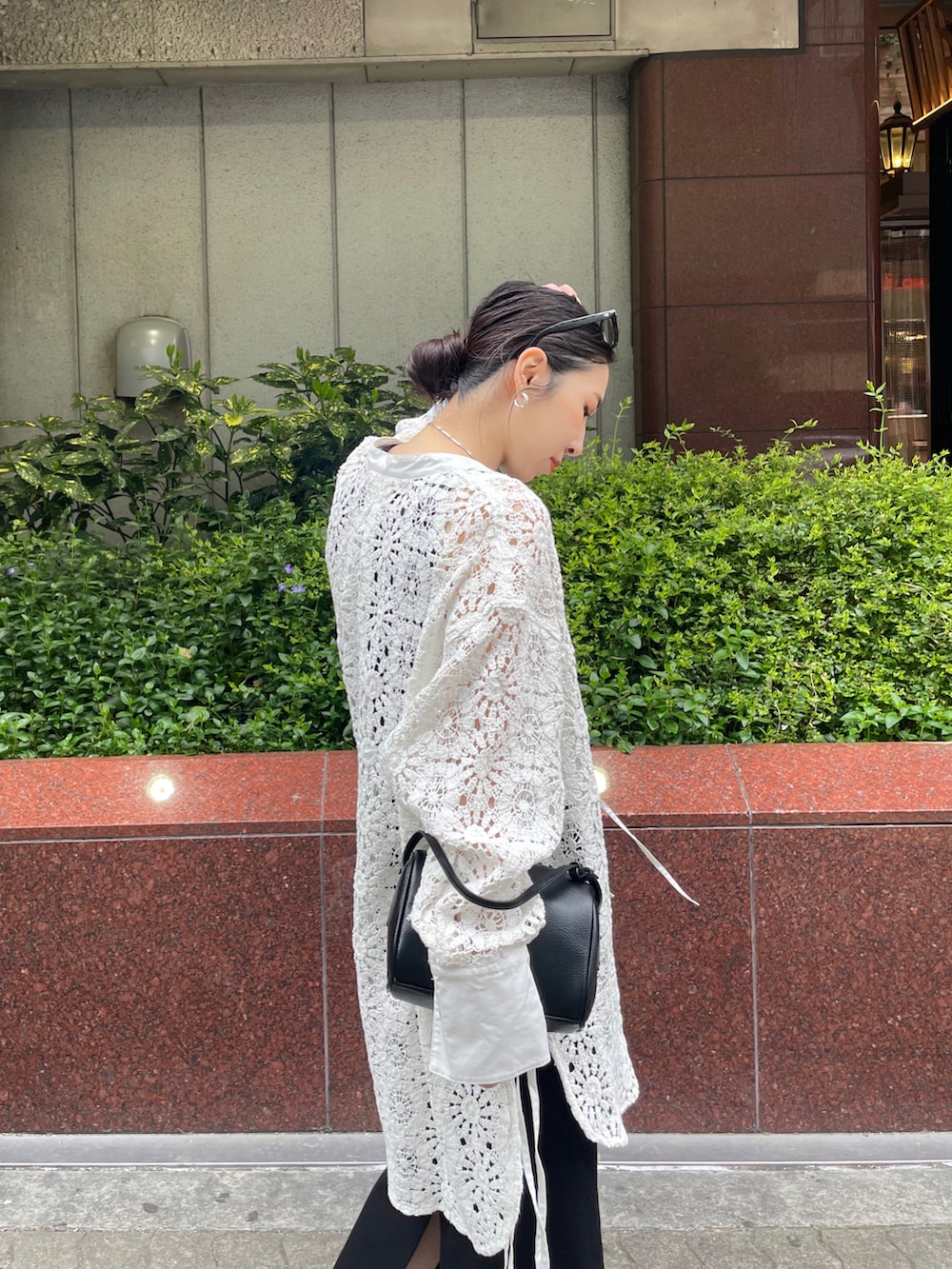 ホワイト系のスニーカー、ブラック系のワンピース、ブラック系のハンドバッグを着用したレディースの春コーディネートの4枚目の写真